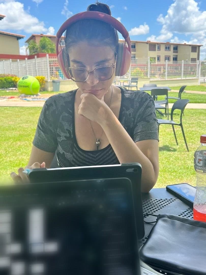 Val trabajando al aire libre con audífonos y una tablet