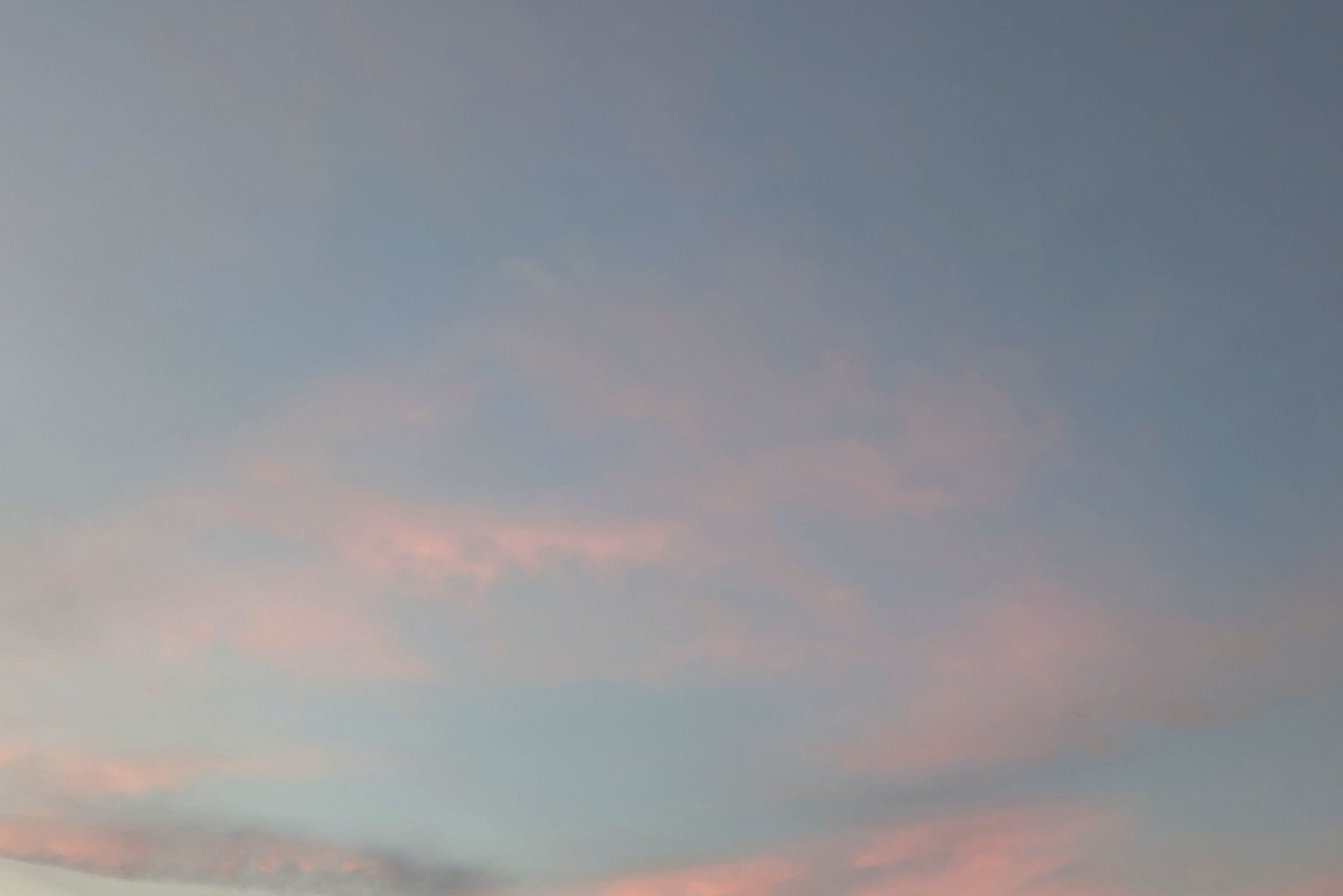 Cielo azul con nubes rosadas al atardecer