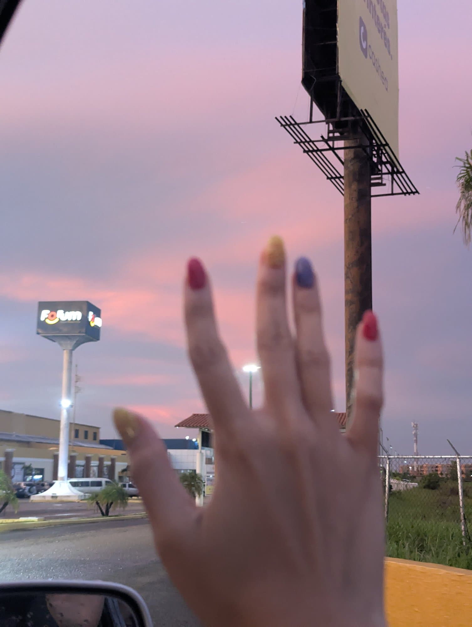 Mano de Val contra un cielo rosado al atardecer